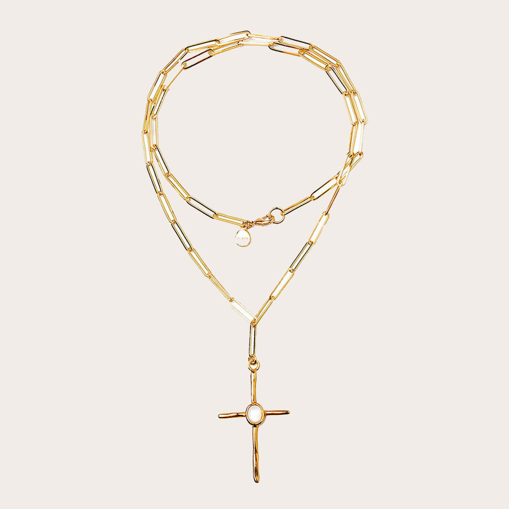 Collar largo de eslabones con colgante de cruz que lleva incrustada una piedra luna. Bañado en oro de 18 quilates. Hecho a mano 100% en España.