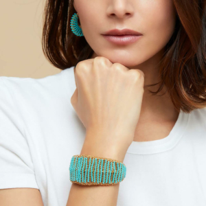 Brazalete dorada con oro fino, compuesta por una base de hilos y cuentas doradas, y adornada con un aderezo de cuentas de colores ensartadas a mano. Tamaño ajustable. Ancho: 3,5 cm - Circunferencia: 14 cm