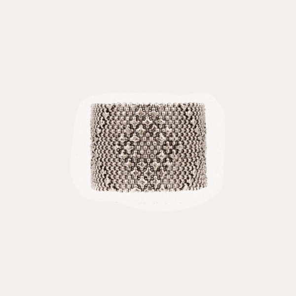 Brazalete  plateado tipo malla compuesto por cadenas de bolas eslabonadas adornadas con cuentas colgantes en forma de estrella. Tamaño ajustable gracias a dos botones. Longitud: 15,5 cm o 18 cm Ancho: 4cm